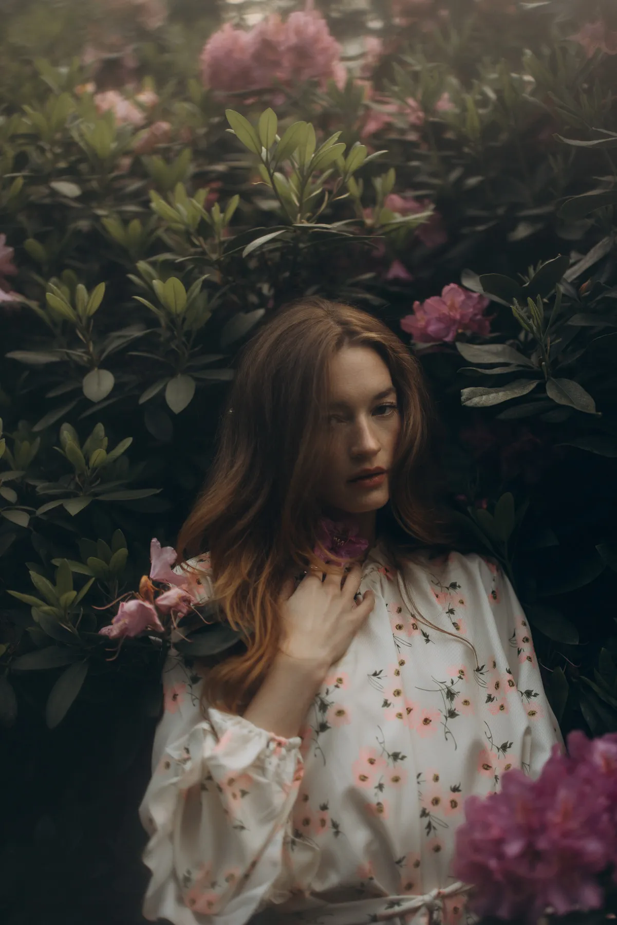 Woman with flowers in front of a flowering rhododendron