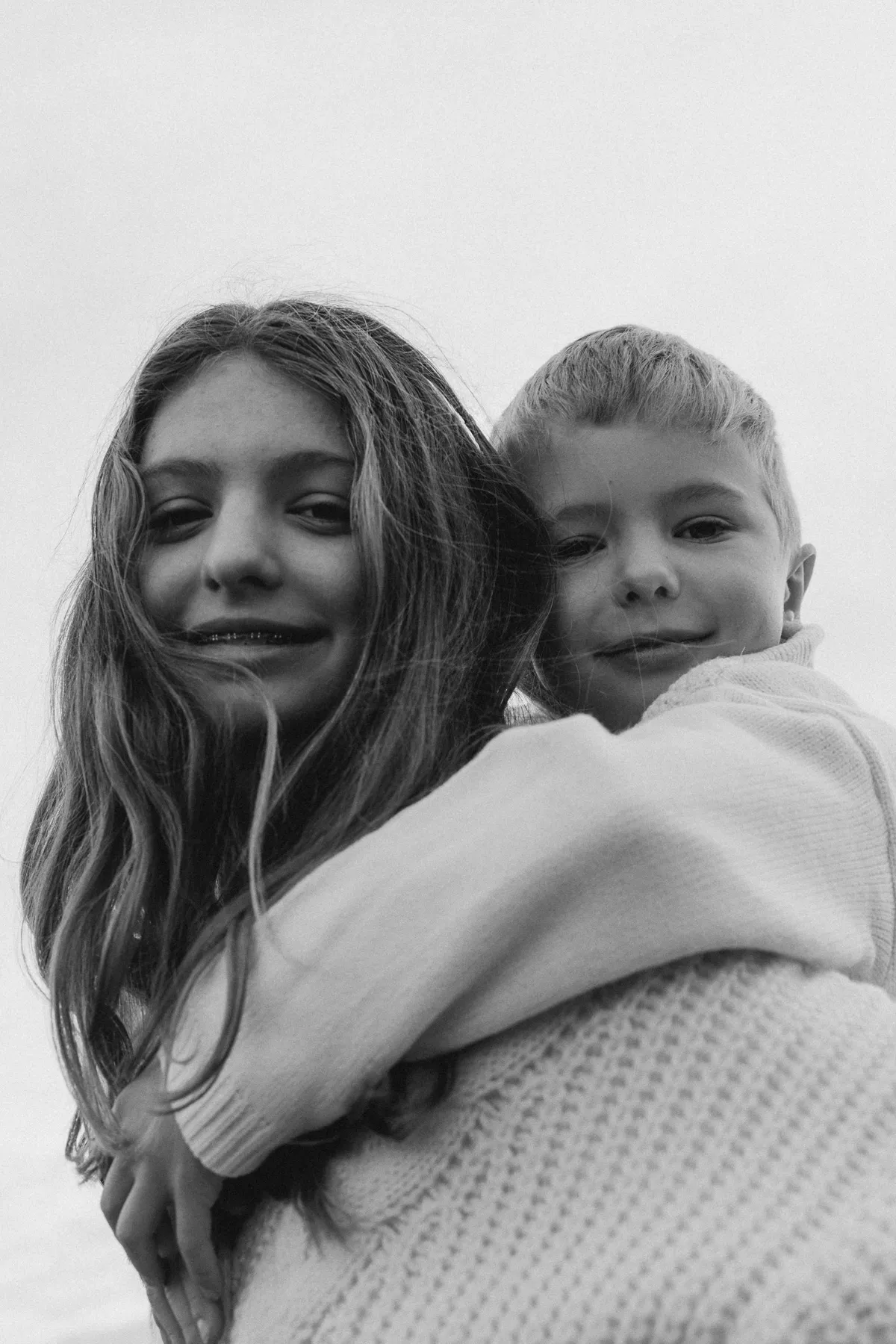 Brother and sister hugging, black and white