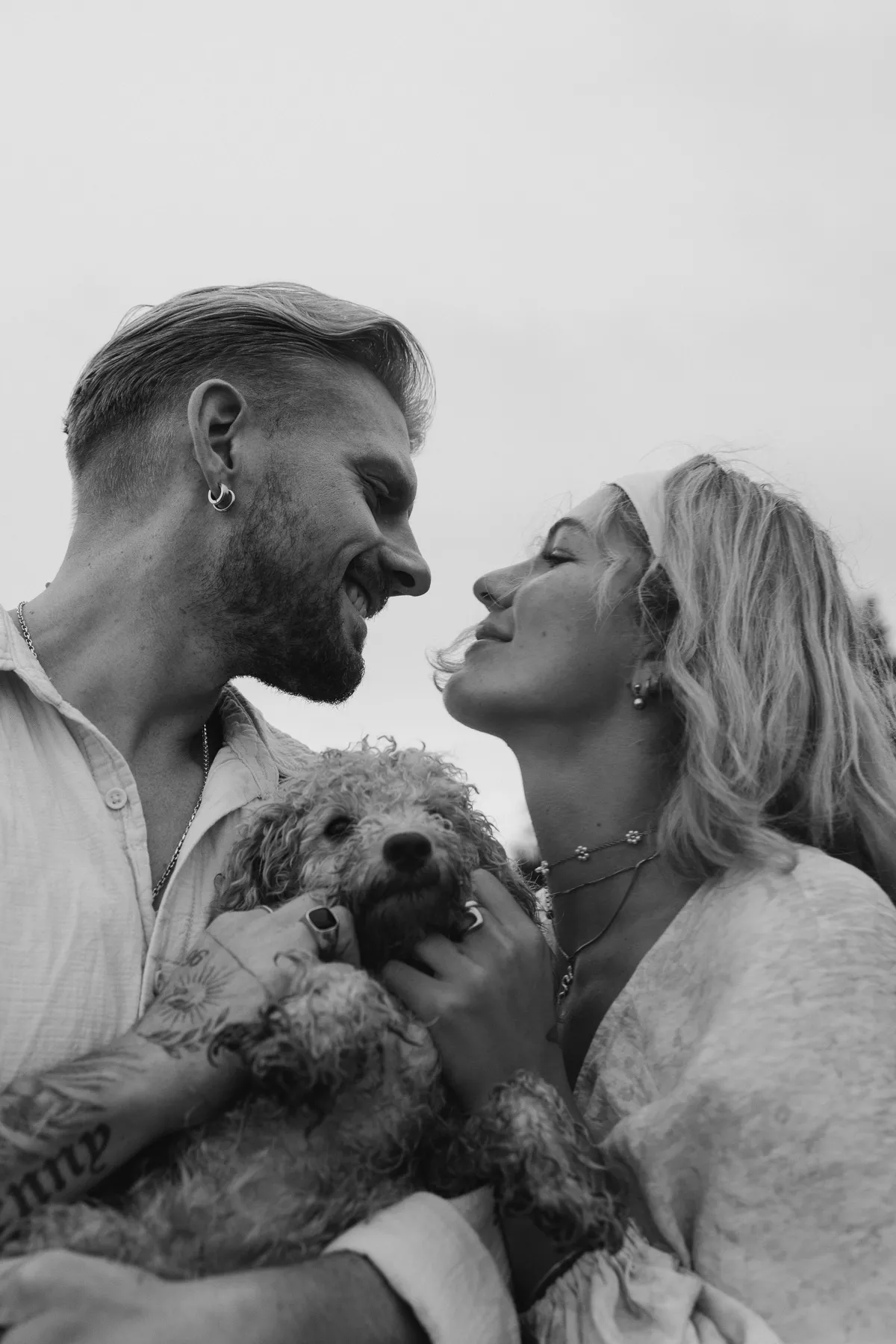 Couple with a dog, both laughing, black and white