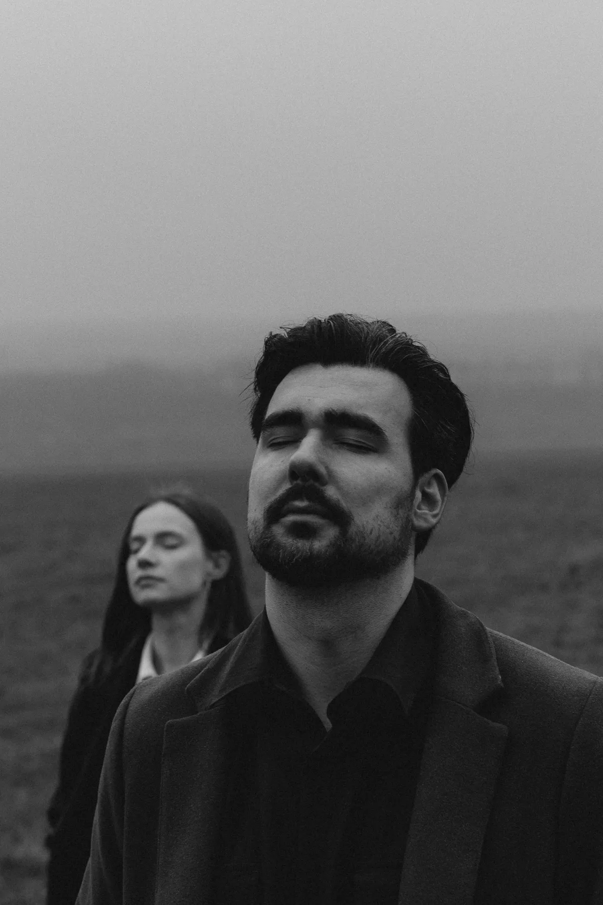 Couple in dark clothes in the fog, black and white