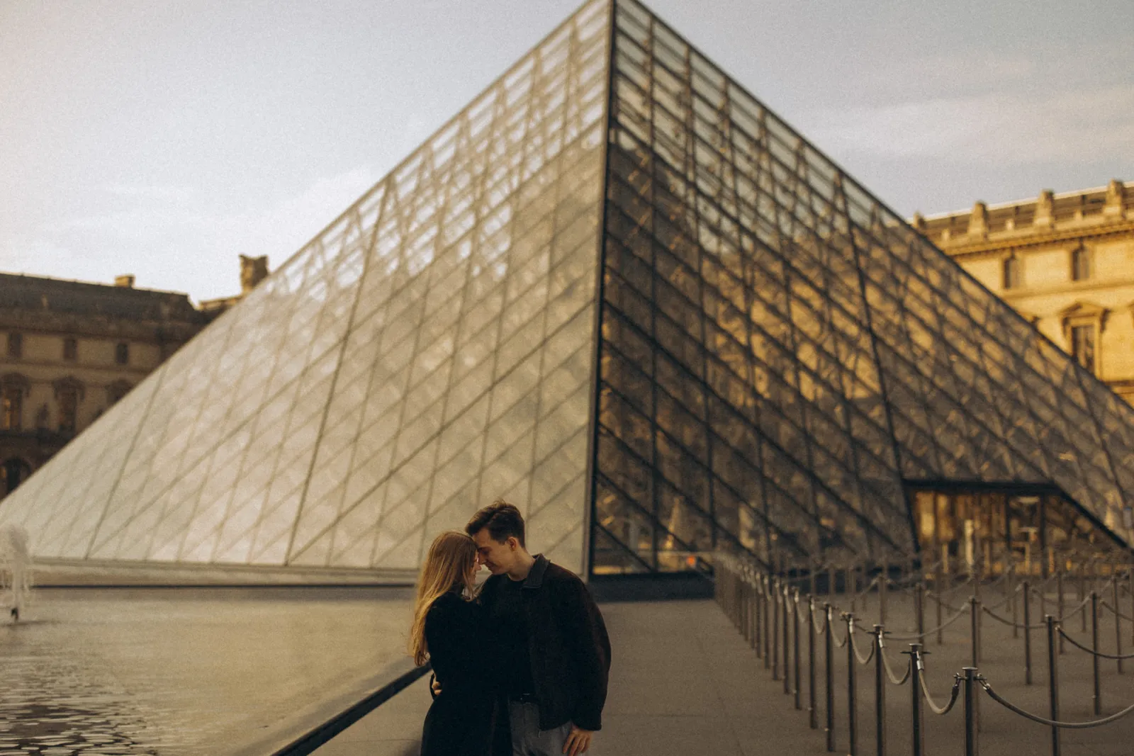 Paar vor der Glaspyramide des Louvre