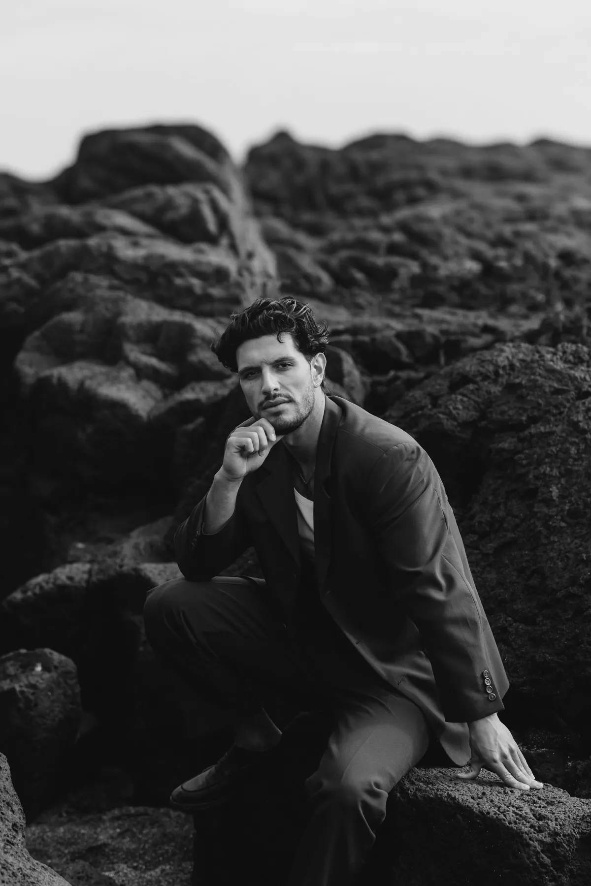 Man sitting on lava rock in Iceland, black and white