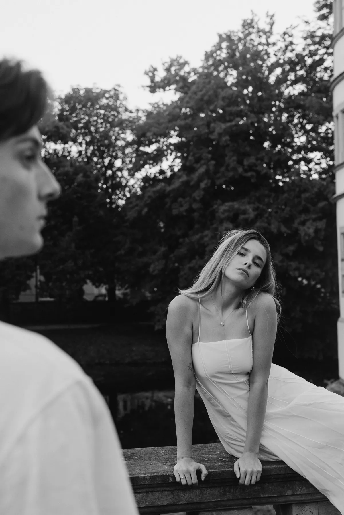 Woman in a white dress sitting on a bench, black and white